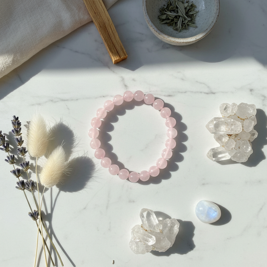 Rose quartz bracelet flat lay with crystals and flowers